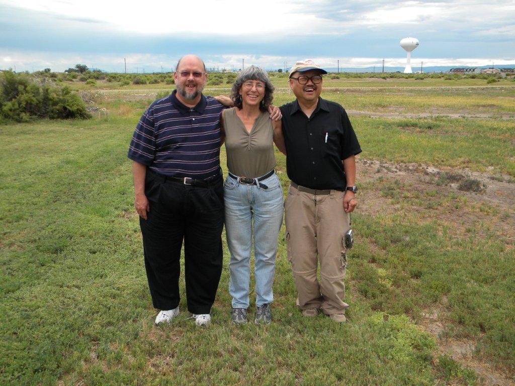 Steve, Mary, Charles standing outside in a field, posing for the camera
